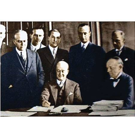 Roca firmando  tratado en compañía de Walter Runciman, en la sala de conferencias del Ministerio de Comercio.